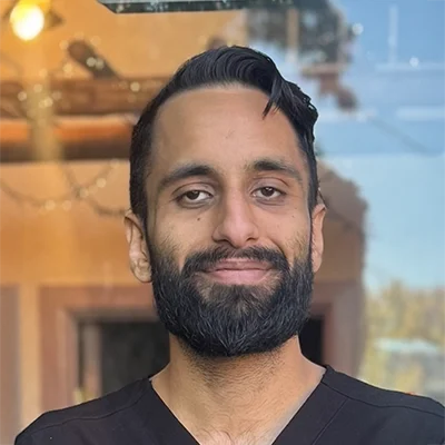 Sukhmeet Mand smiling while wearing a black shirt.